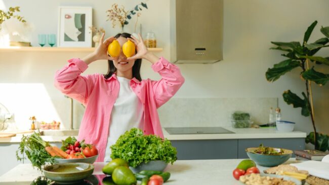 Girl in kitchen holding lemons