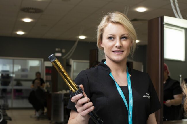 Student holding hair curler