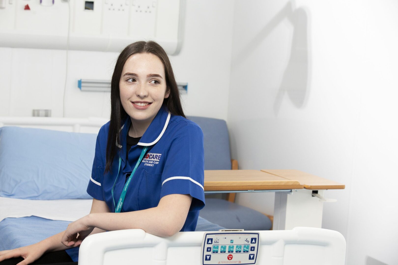Health care student sitting on ward bed