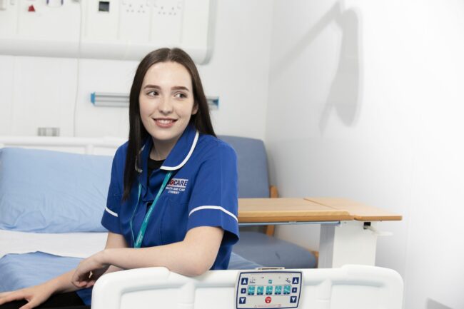 Health care student sitting on ward bed