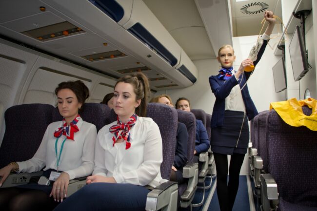 Student showing oxygen mask in simulated aircraft cabin