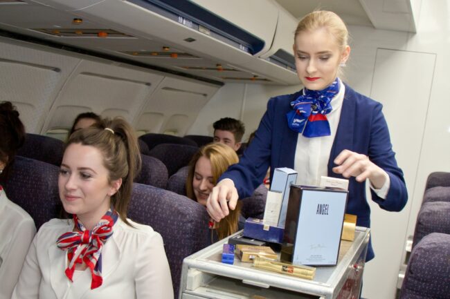 Student pushing trolley in simulated aircraft cabin