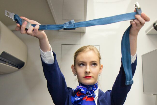 Student showing aircraft seatbelt