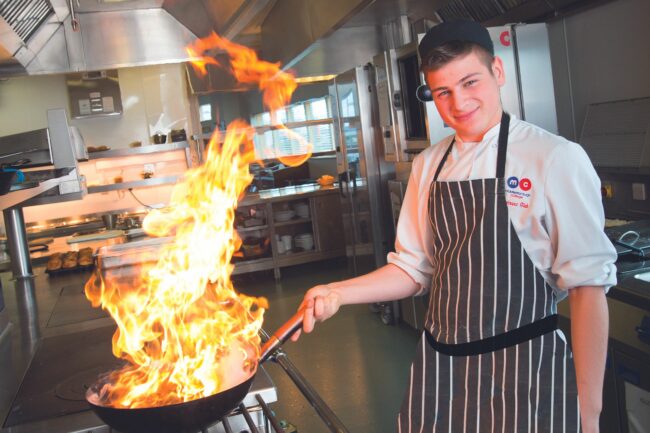 Student cooking with wok