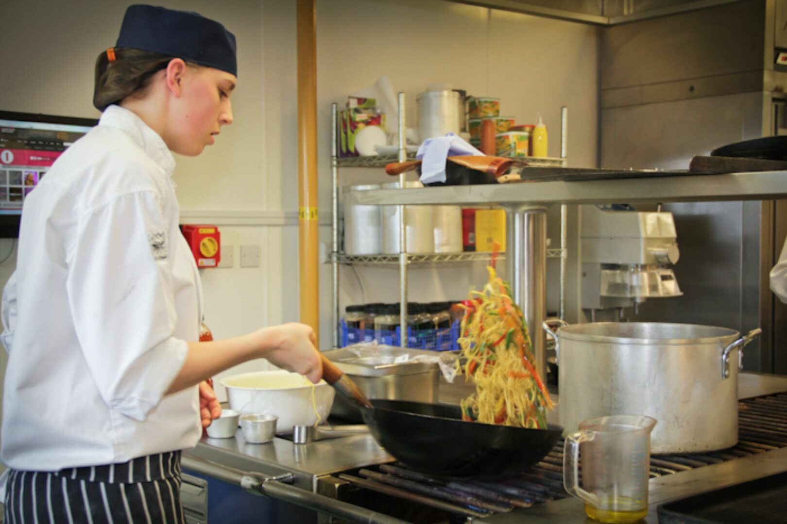 Student cooking using wok
