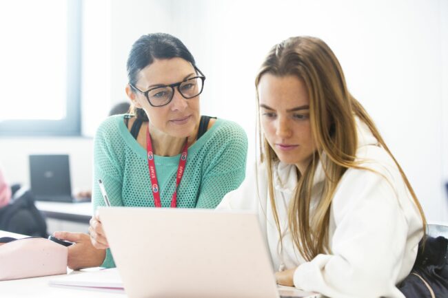 Tutor and student looking at laptop