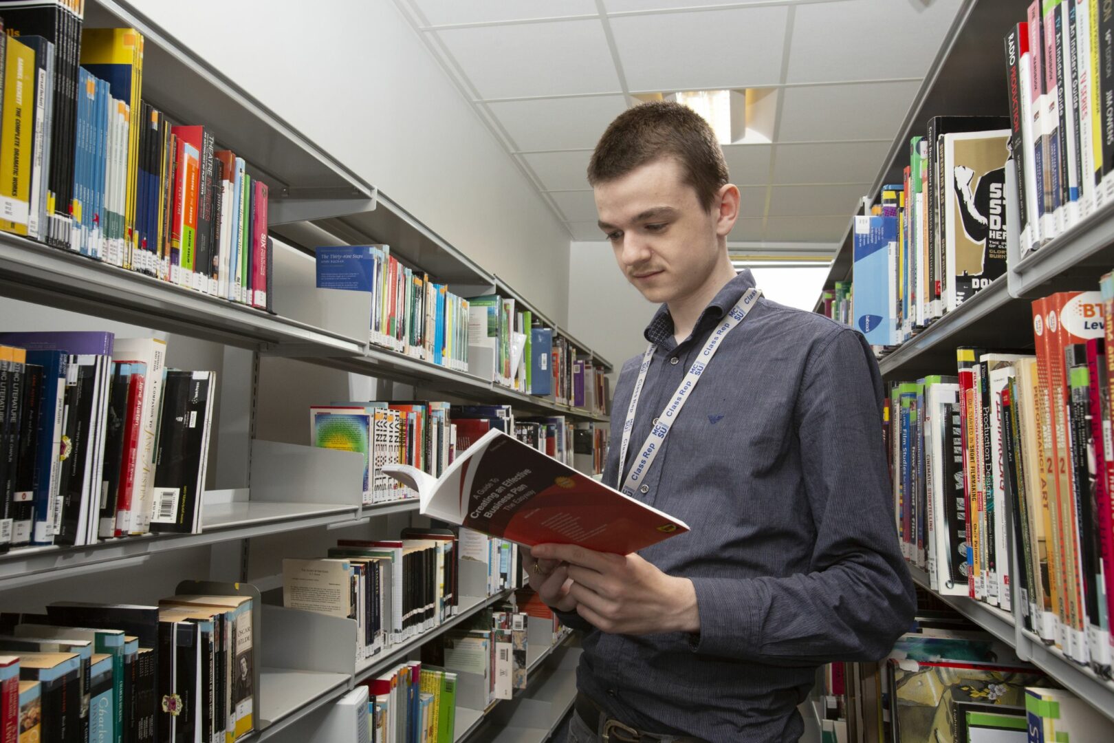 Business student reading book in library