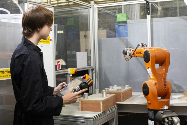 Engineering student with robot arm