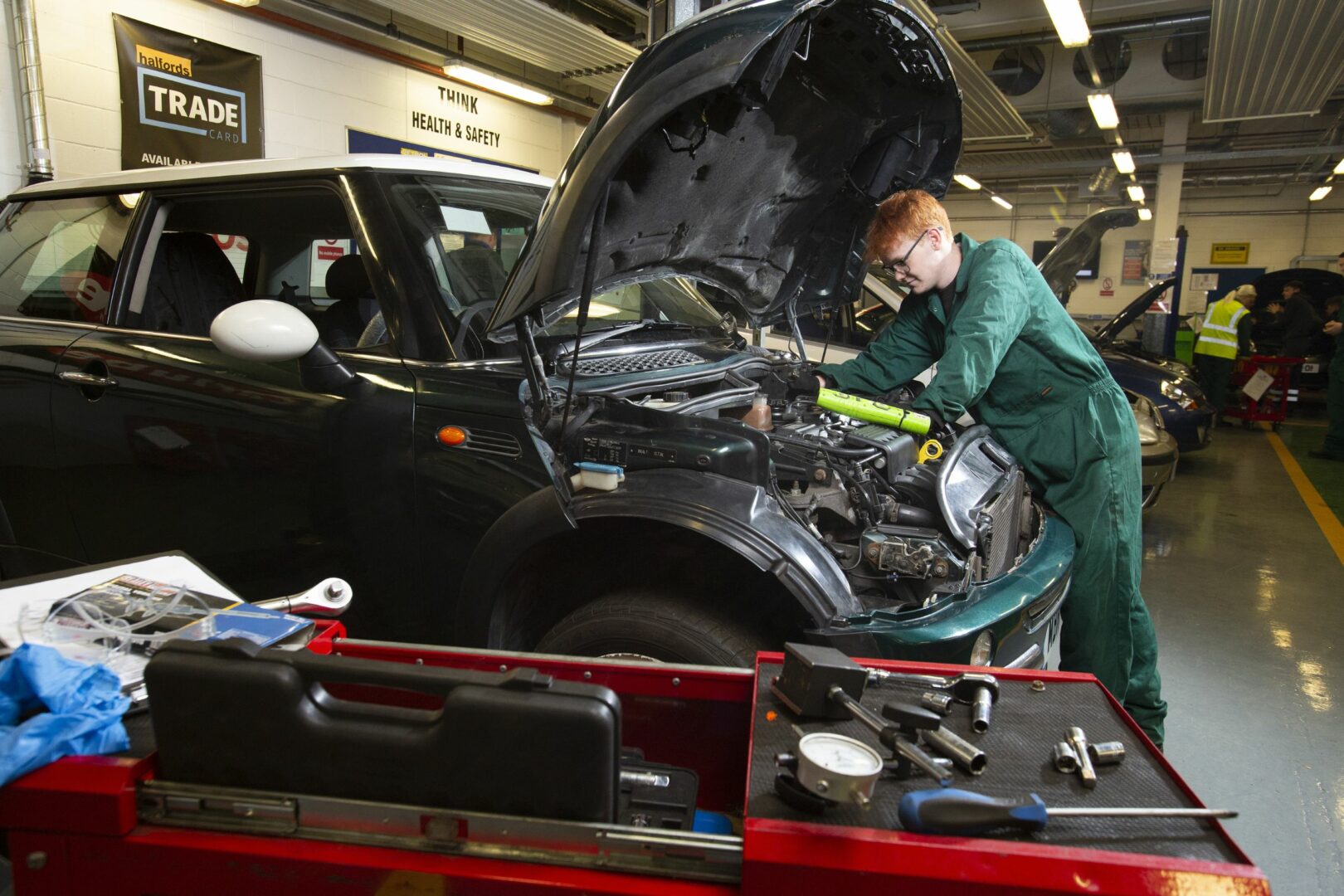 Motor vehicle students working on car engine