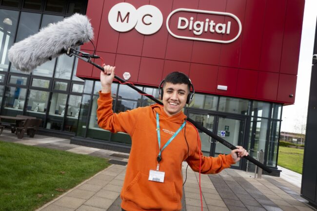 Media student holding a boom mic