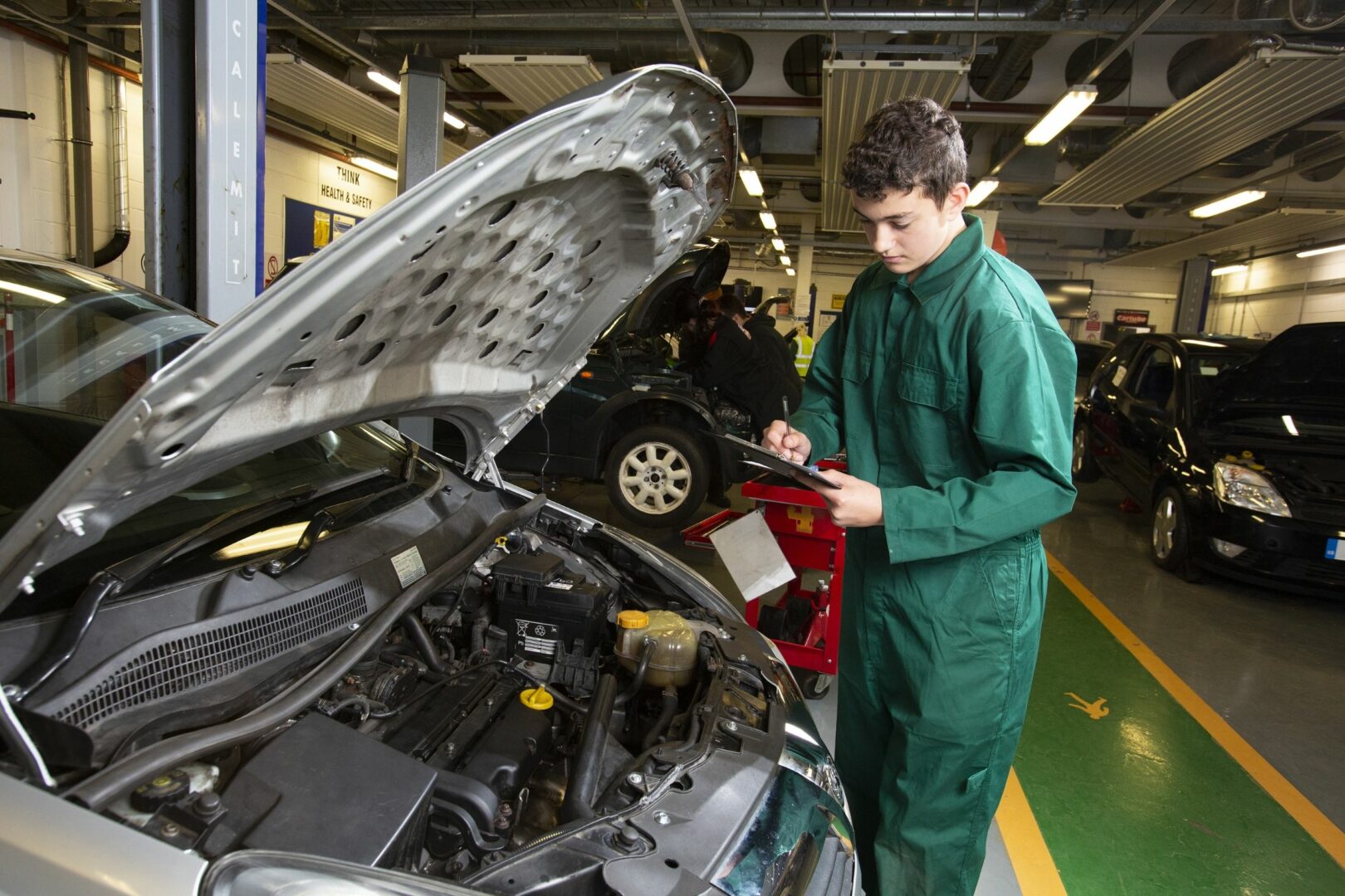 Motor vehicle student working on car