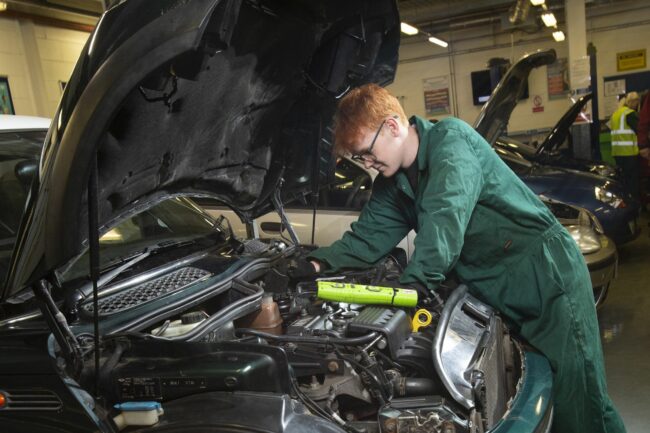 Motor vehicle student working on engine