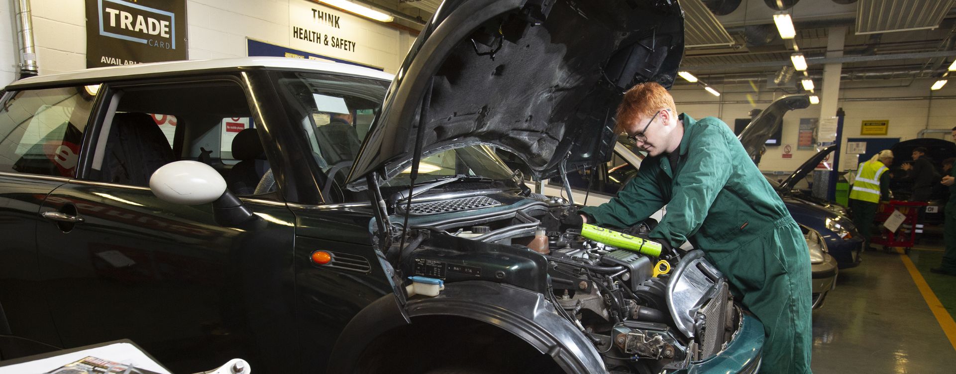 Motor vehicle student working on engine