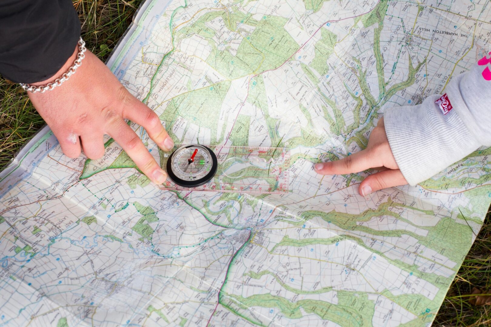 Two hands pointing at map