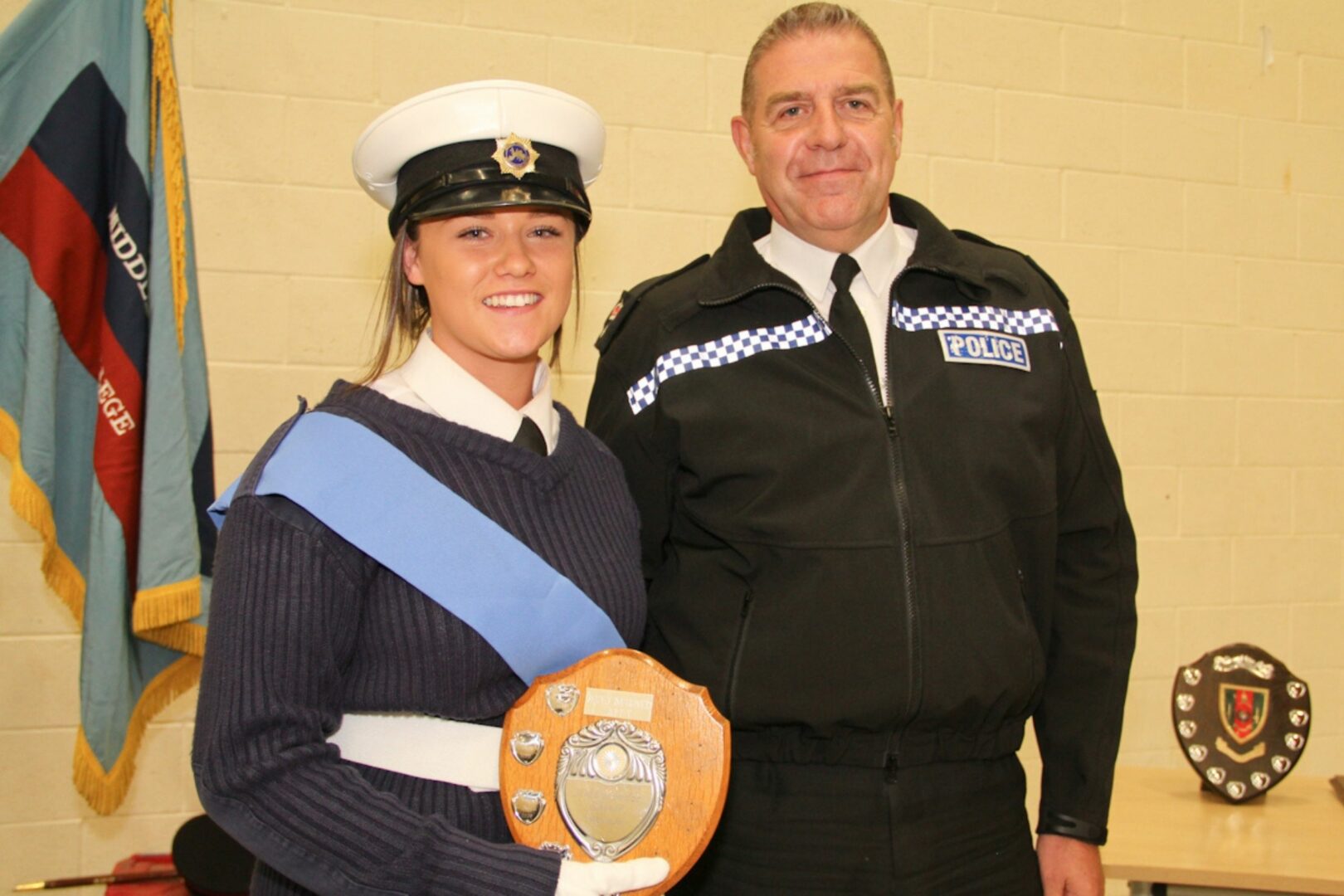 Public services student wearing uniform next to police officer