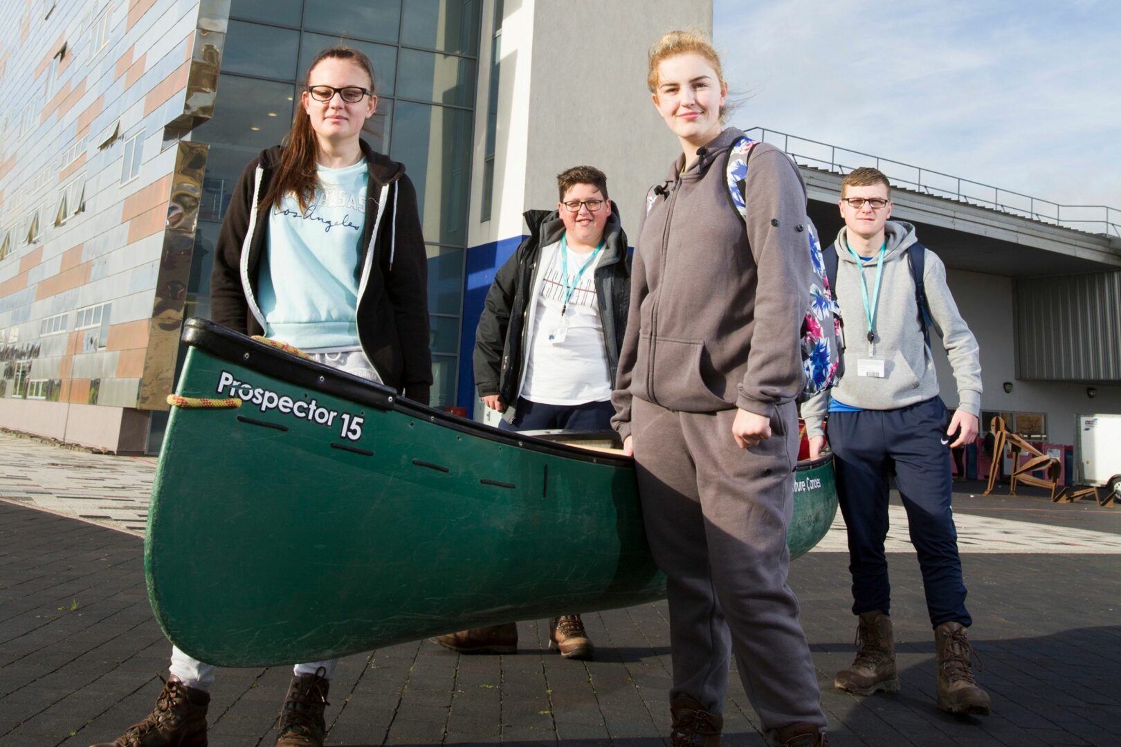 Public services students holding up a kayak