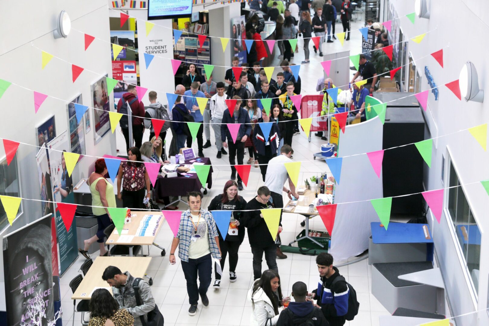 Busy college building with stands and people walking