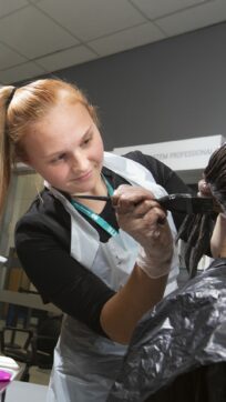 Hairdressing student dyeing hair