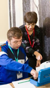 Life skills student learning to use a till