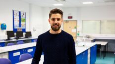 Aiman Aziz standing in science classroom