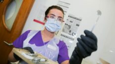 Dental nurse apprentice holding medical equipment