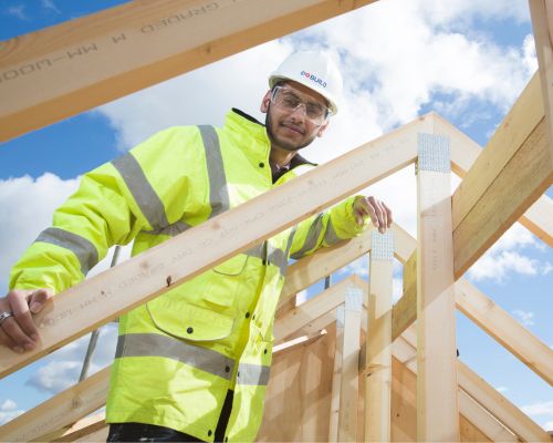 Construction student standing on wooden frame