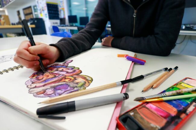 Creative arts student working in sketchbook