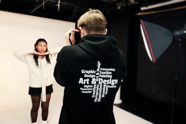 Creative arts student taking photograph of another student