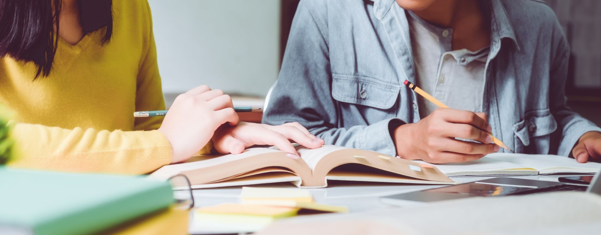 Two people writing in books