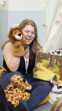 Childcare student with puppet and book