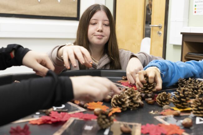 Childcare student looking at acorns