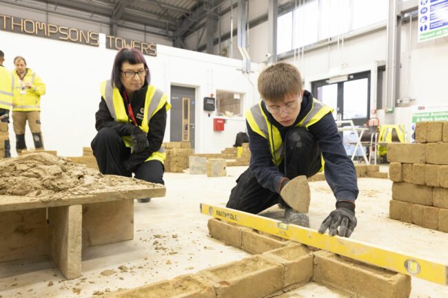 Construction student and tutor with spirit level