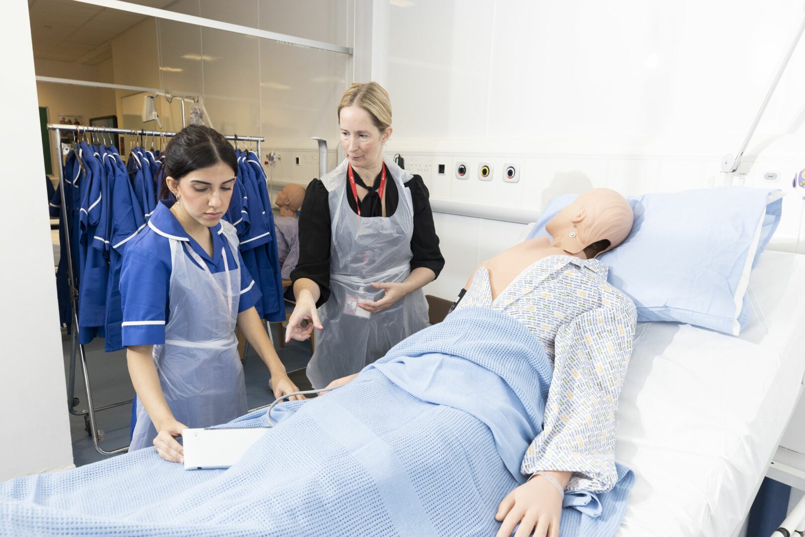 Health and care student and tutor practising on medical dummy