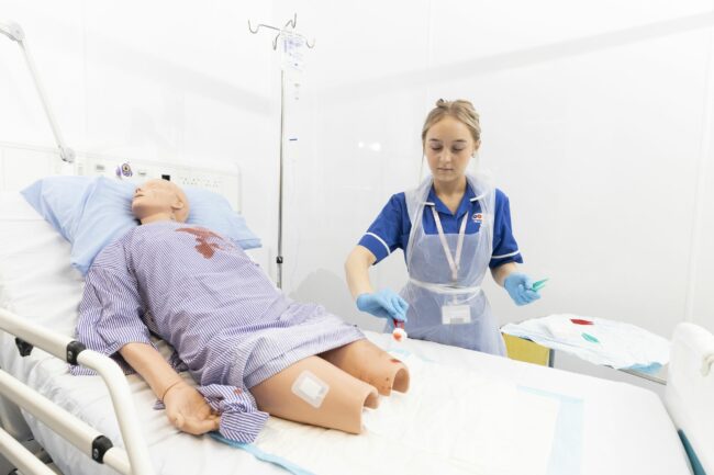 Health and care student practising on medical dummy