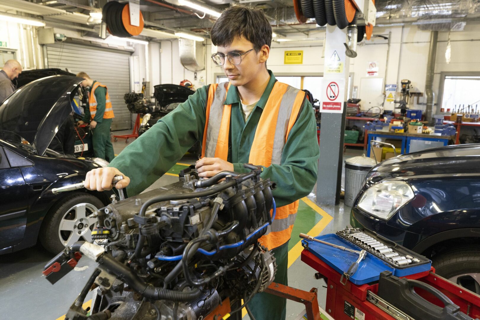 Motor vehicle student working on engine