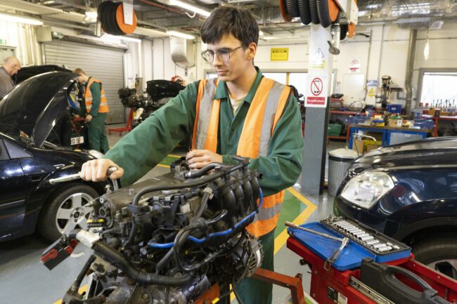 Motor vehicle student working on engine