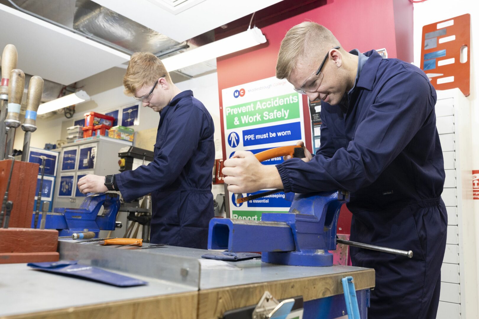 Engineering students sawing pipes