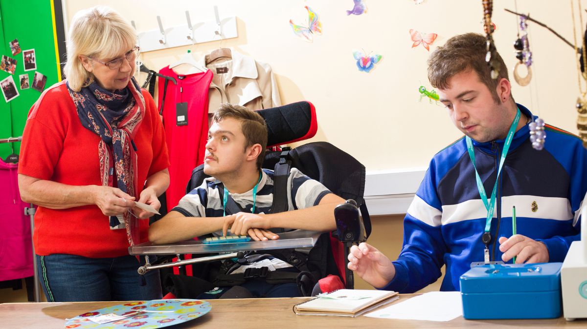 ALS students with tutor working in shop