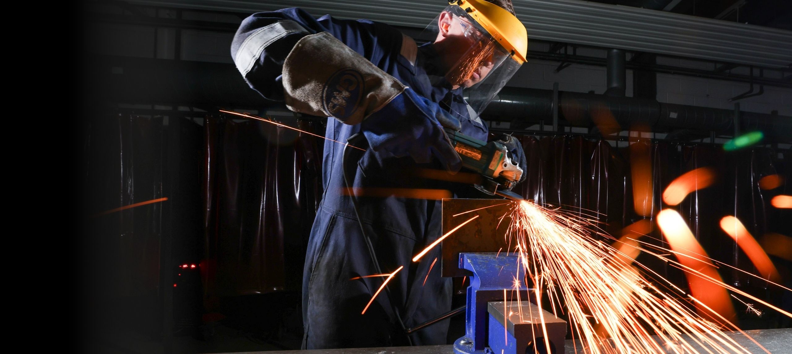 Welding student grinding a piece of metal