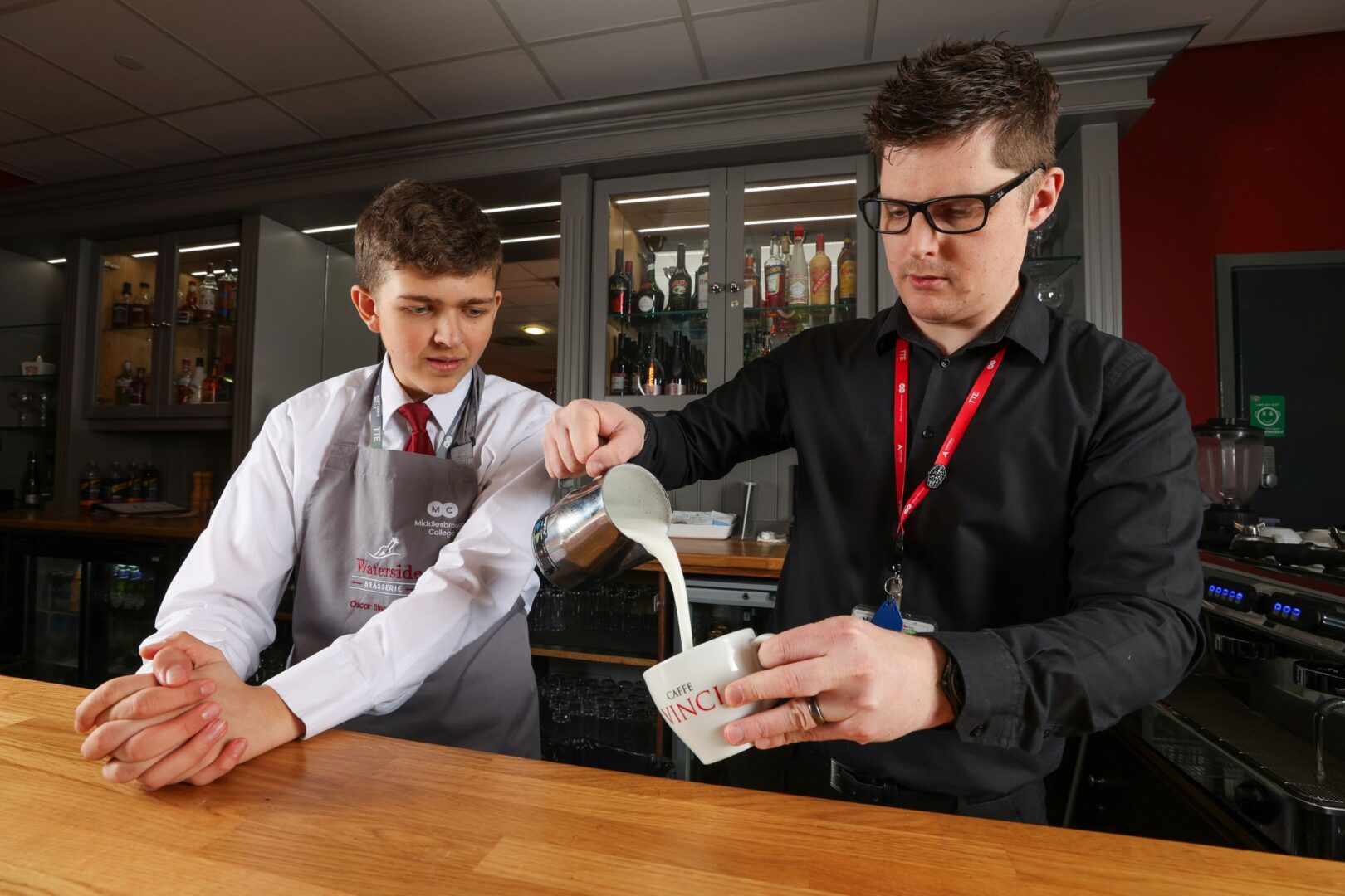 Student And Tutor Pouring Milk