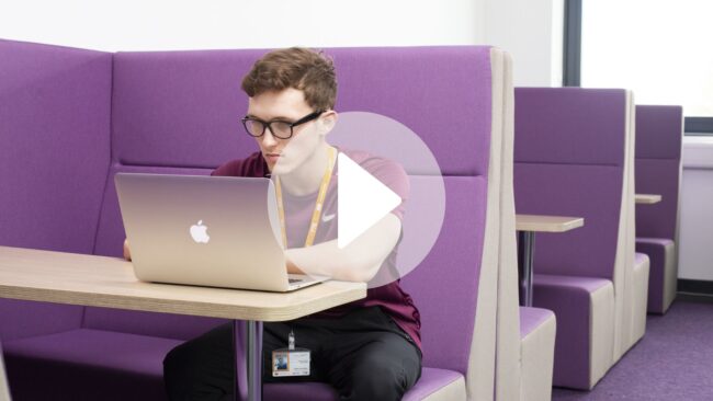 Student working on laptop in HE Study lounge