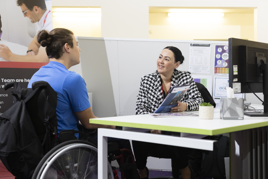 student speaking to staff member