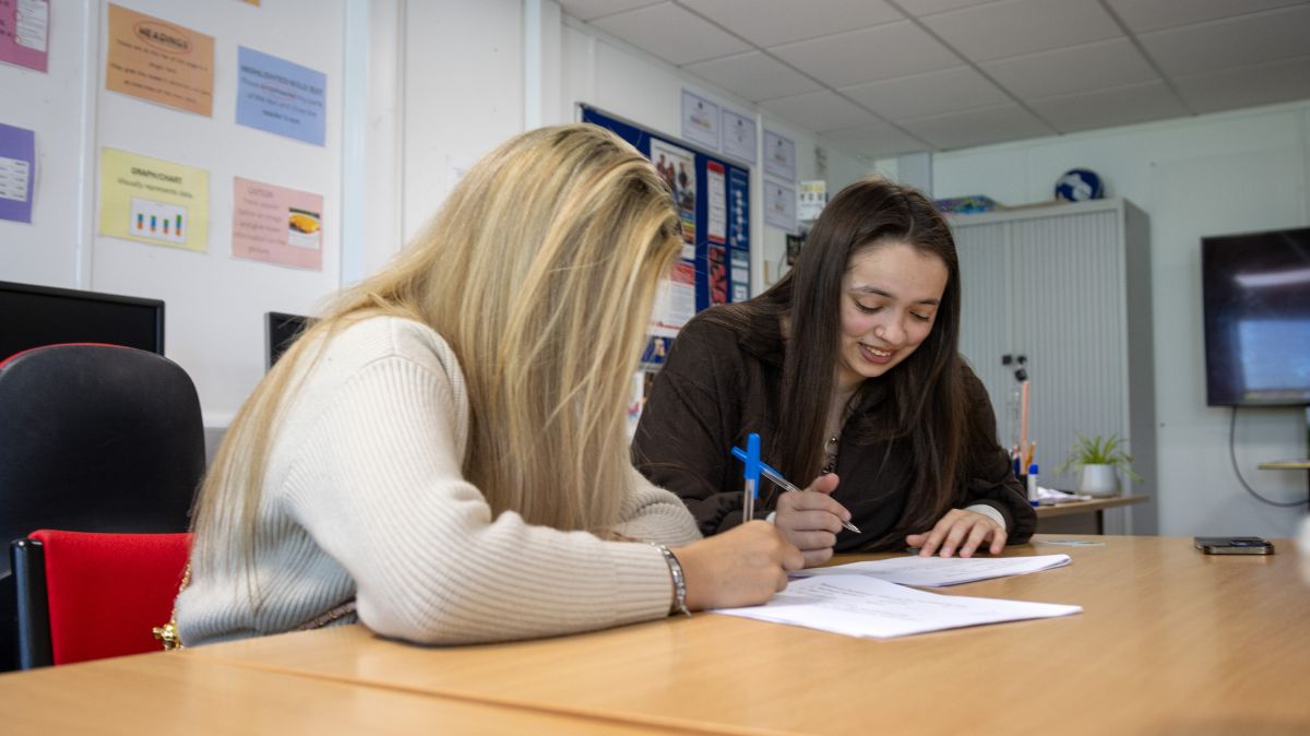 Two learners in the ROOTS programme classroom