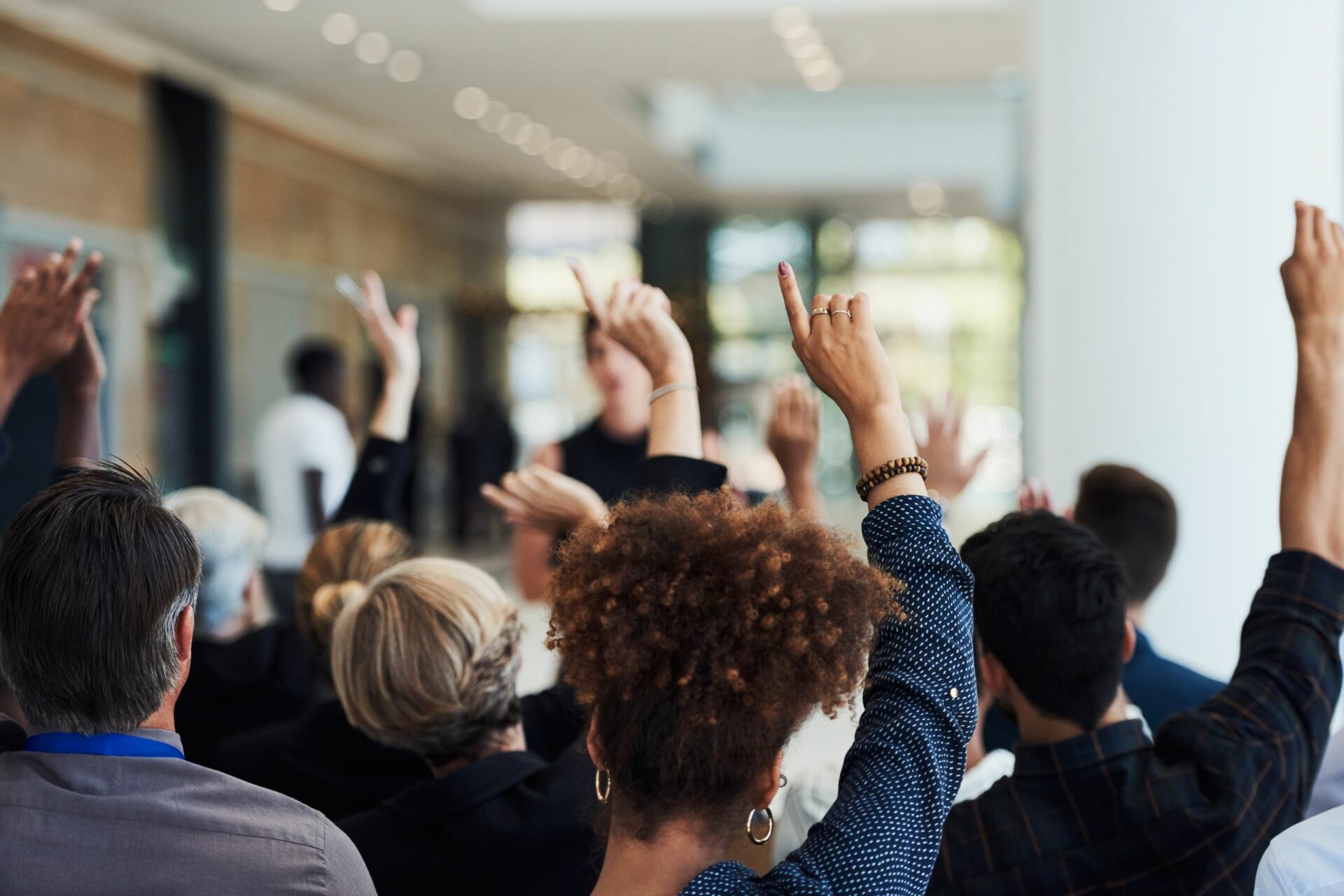 Group of hands in the air during a meeting