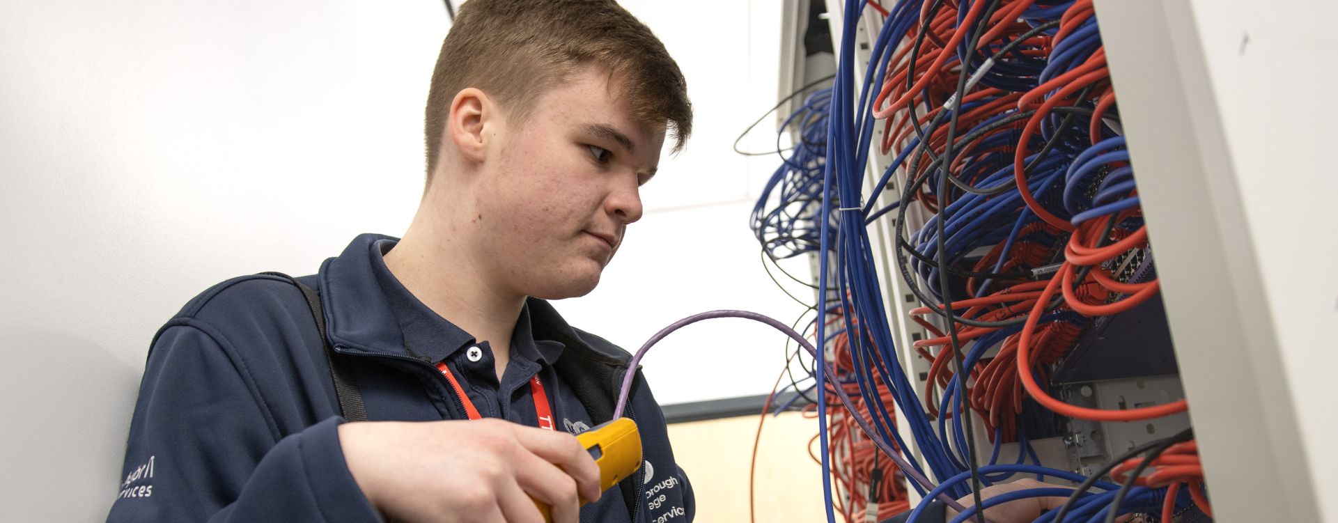 IT apprentice looking at cables