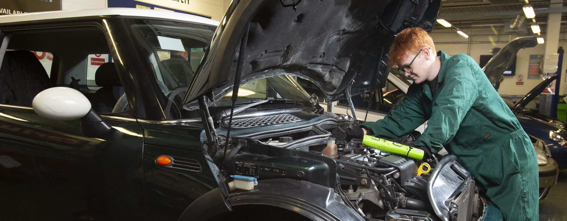 Student working on engine of car